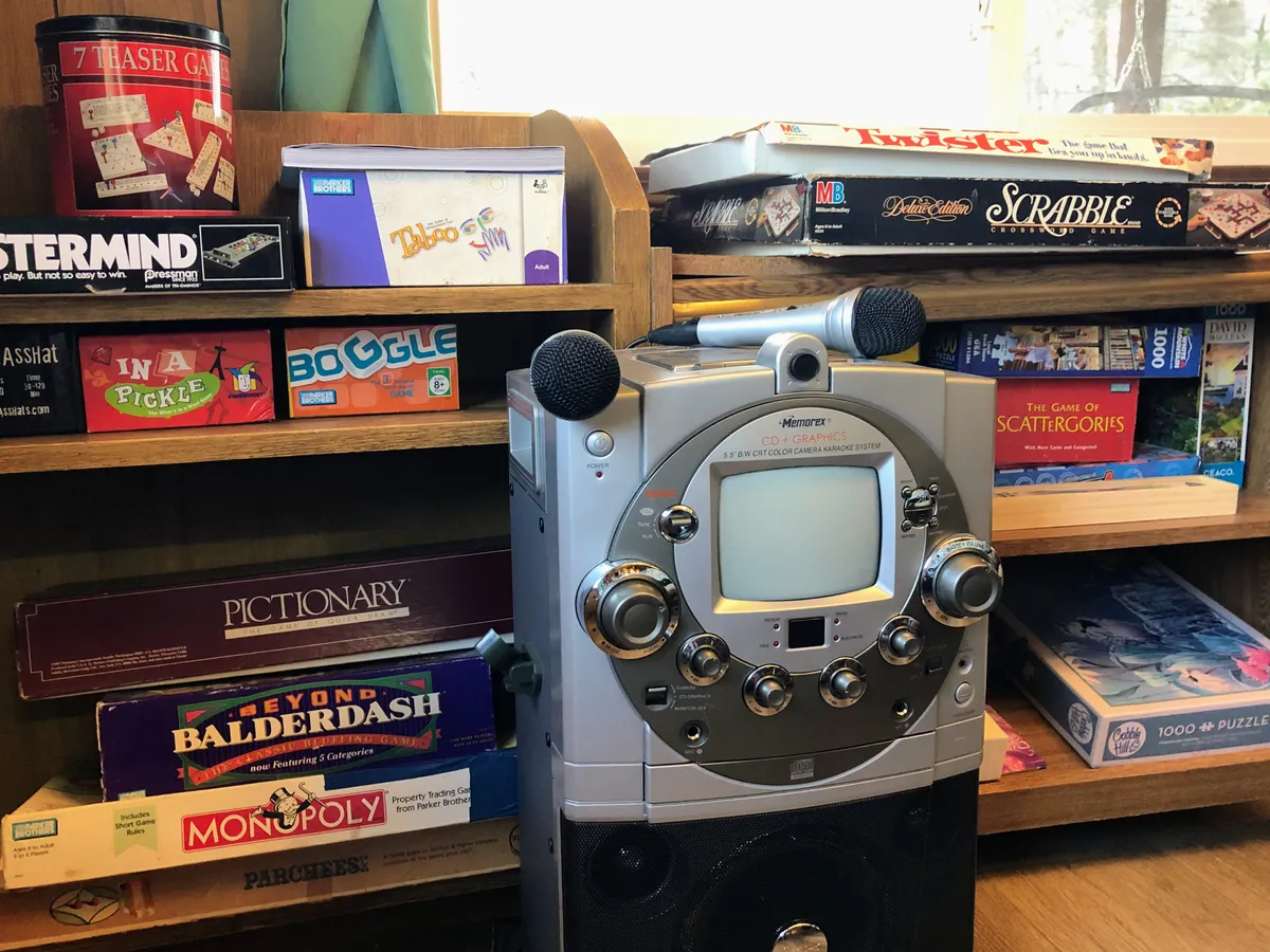 A shelf brimming with a variety of board games and a retro stereo system evoke a sense of nostalgia and togetherness, hinting at lively game nights and impromptu sing-alongs.